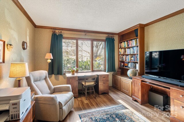 office with ornamental molding, light hardwood / wood-style floors, and a textured ceiling