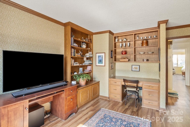 home office featuring crown molding, built in desk, a textured ceiling, and light hardwood / wood-style flooring