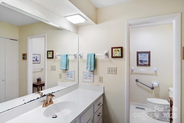 bathroom featuring vanity, toilet, and tile patterned flooring