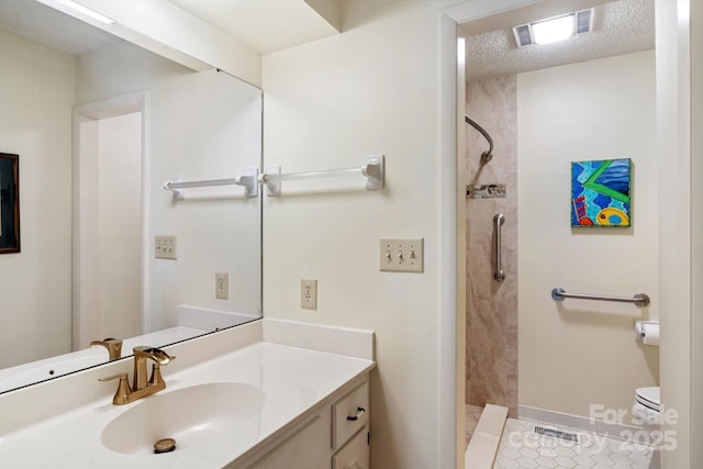 bathroom featuring tiled shower, tile patterned floors, toilet, a textured ceiling, and vanity