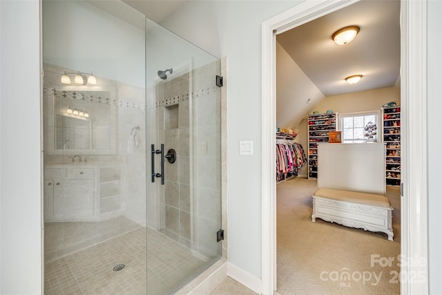 bathroom featuring vaulted ceiling and a shower with shower door