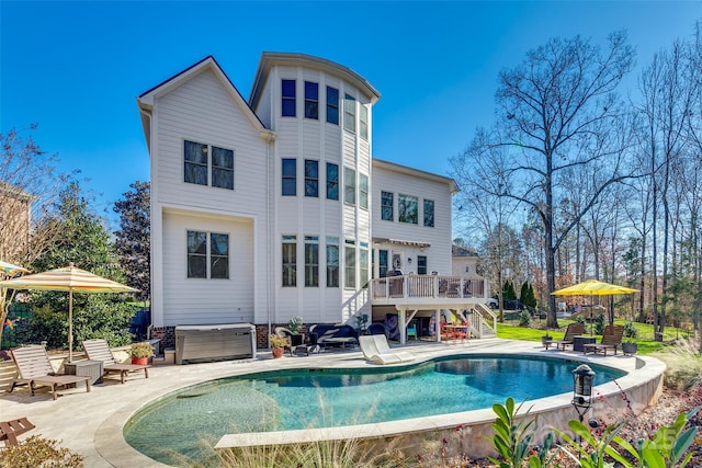 rear view of house featuring a patio and a pool with hot tub