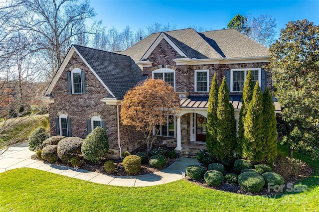 view of front of home with a porch, a front yard, and central AC