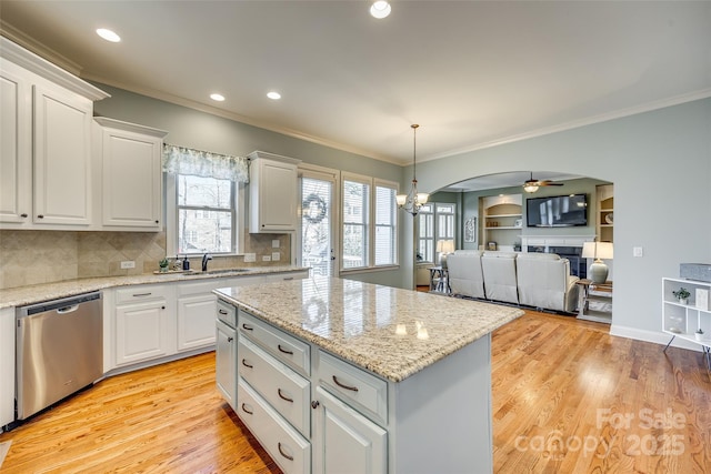 kitchen with a center island, dishwasher, white cabinets, and ceiling fan with notable chandelier