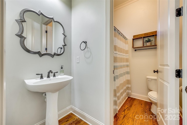 bathroom with hardwood / wood-style flooring, toilet, curtained shower, and sink