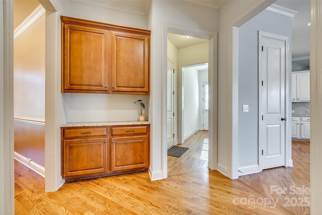 interior space featuring decorative backsplash, light hardwood / wood-style floors, and crown molding