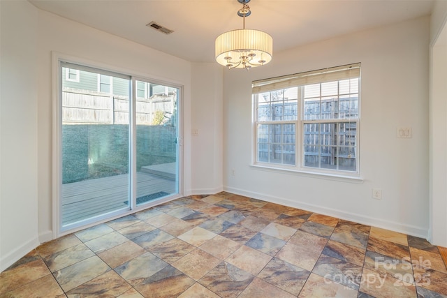 unfurnished room featuring a notable chandelier