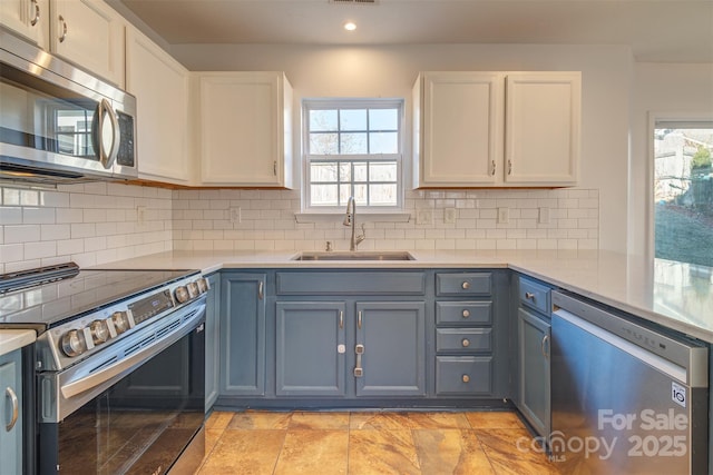 kitchen featuring white cabinetry, appliances with stainless steel finishes, sink, and decorative backsplash