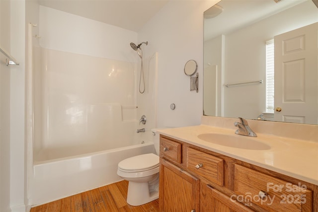 full bathroom featuring hardwood / wood-style flooring, vanity, bathtub / shower combination, and toilet