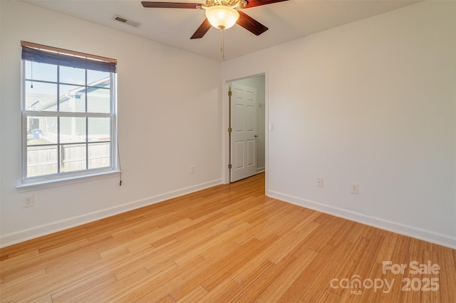 empty room with ceiling fan and light hardwood / wood-style flooring