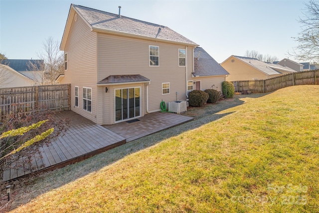 rear view of property with a yard, cooling unit, and a deck