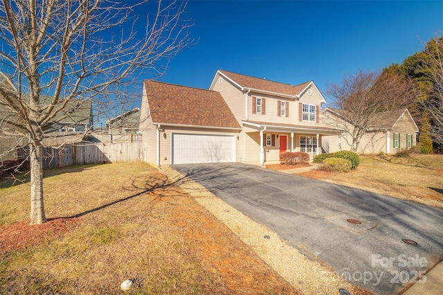 view of property featuring a garage, a front yard, and covered porch