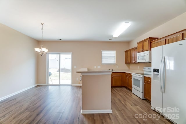 kitchen with an inviting chandelier, hanging light fixtures, white appliances, and light wood-type flooring