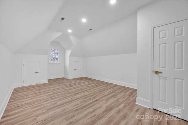 bonus room with lofted ceiling and light hardwood / wood-style floors