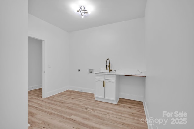 washroom with sink, light hardwood / wood-style flooring, electric dryer hookup, cabinets, and washer hookup