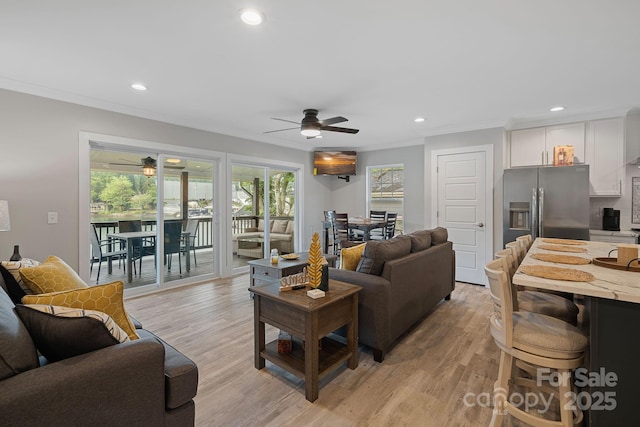 living room with ceiling fan, light hardwood / wood-style flooring, and crown molding