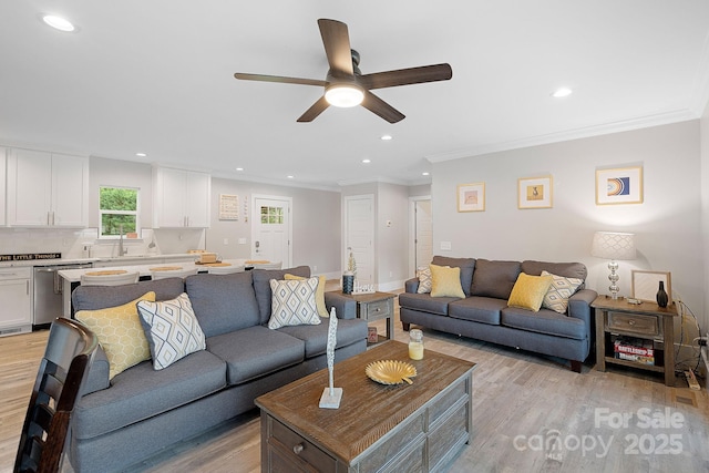 living room featuring crown molding, sink, ceiling fan, and light hardwood / wood-style flooring