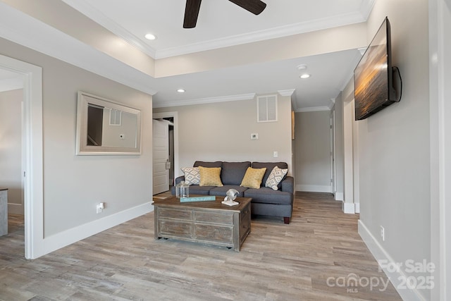 living room with light hardwood / wood-style floors, ceiling fan, and ornamental molding