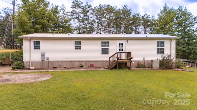 rear view of property with central AC and a lawn