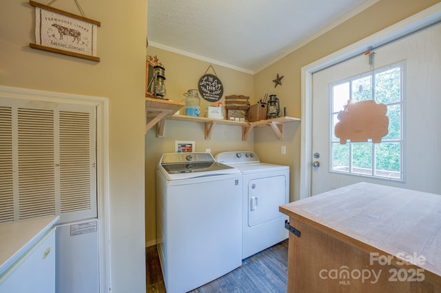 laundry room featuring a textured ceiling, dark hardwood / wood-style flooring, crown molding, and washing machine and clothes dryer