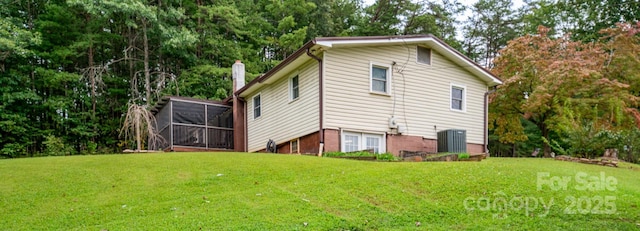 rear view of property with a yard and central air condition unit