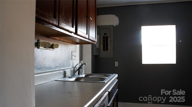 kitchen featuring electric panel, sink, and dark brown cabinets