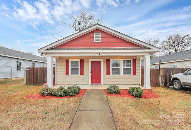 bungalow featuring covered porch and a front lawn