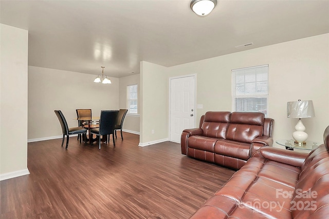 living room with dark hardwood / wood-style floors and a chandelier