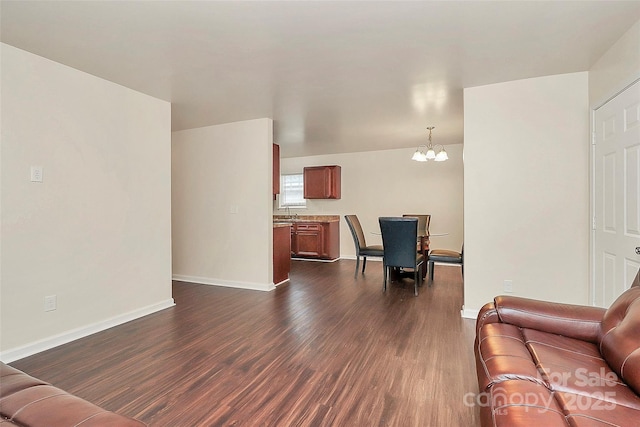 living room with dark hardwood / wood-style flooring, sink, and an inviting chandelier