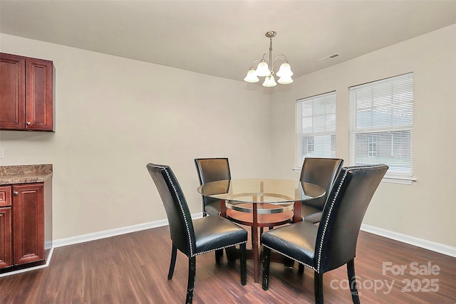 dining space featuring dark hardwood / wood-style floors and a chandelier