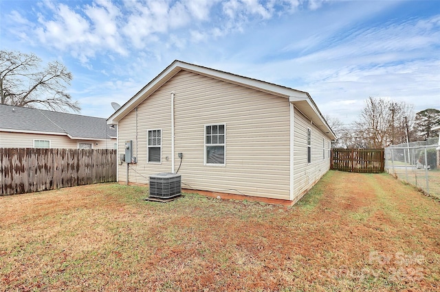 back of house featuring a yard and central air condition unit