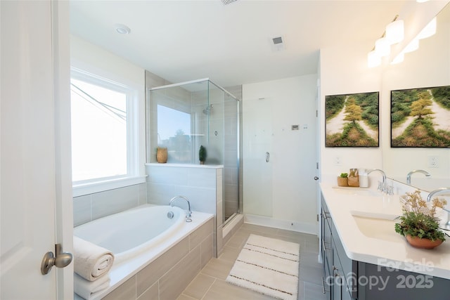 bathroom with tile patterned flooring, vanity, and plus walk in shower