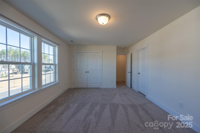 unfurnished bedroom featuring carpet and a closet