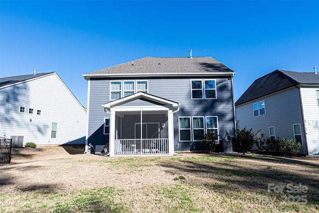 rear view of house featuring a sunroom and a yard