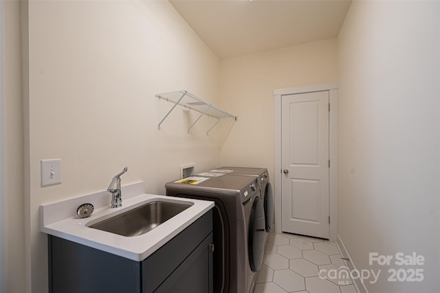 laundry area with light tile patterned flooring, separate washer and dryer, and sink