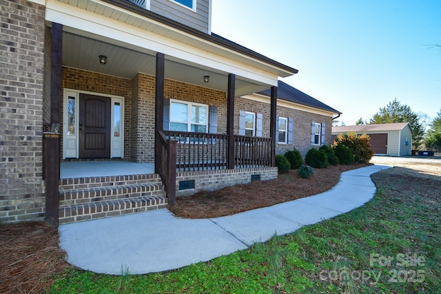 doorway to property featuring a lawn and covered porch