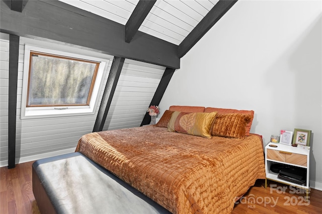 bedroom with beamed ceiling and dark hardwood / wood-style floors