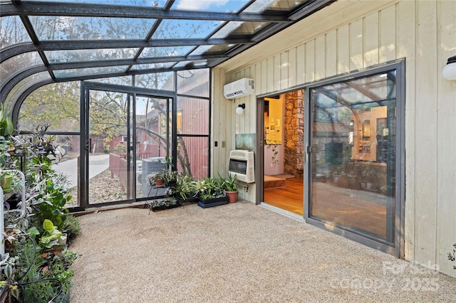 unfurnished sunroom with heating unit, lofted ceiling, and a wall mounted air conditioner