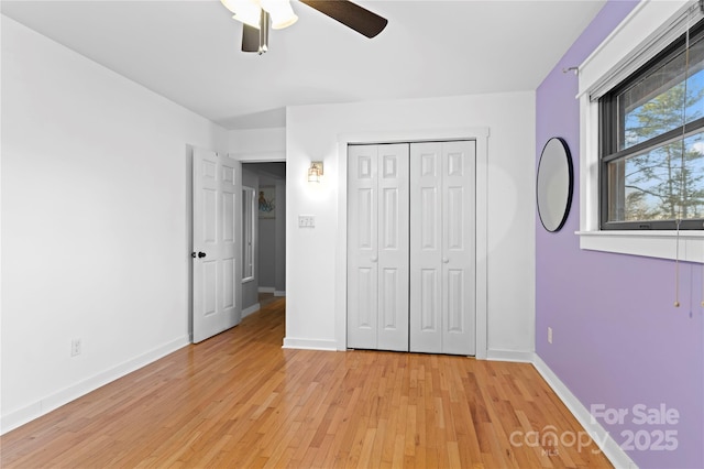 unfurnished bedroom with ceiling fan, light hardwood / wood-style flooring, and a closet