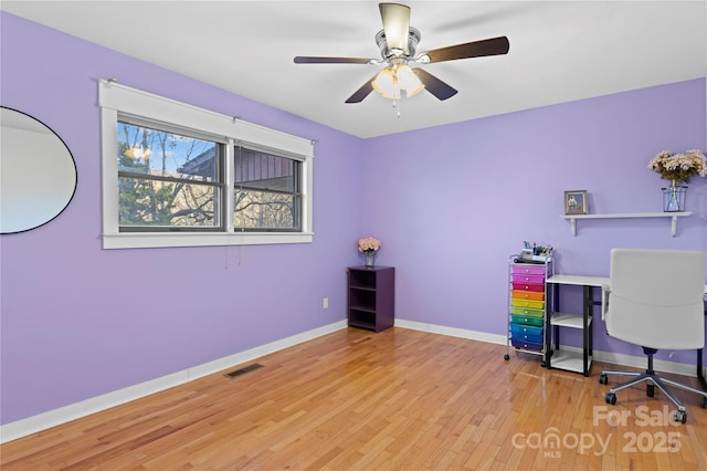 home office with wood-type flooring and ceiling fan