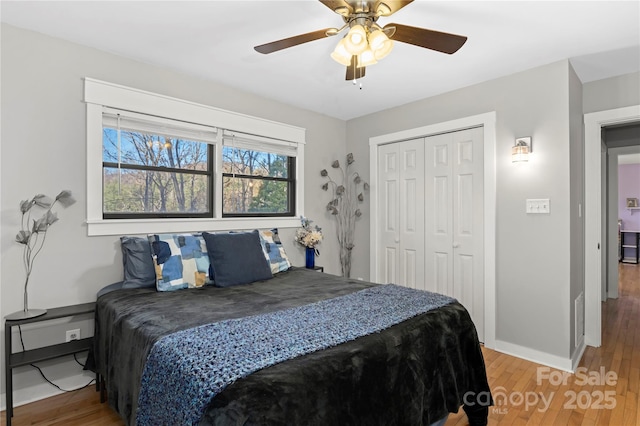 bedroom with hardwood / wood-style flooring, ceiling fan, and a closet