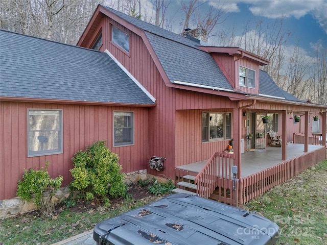 back of property featuring a porch and a wooden deck