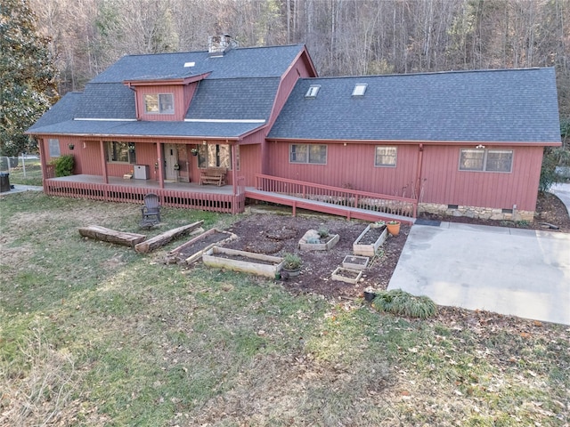 back of property featuring a deck and a yard