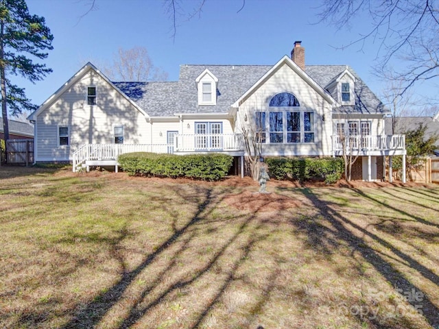 back of property featuring a wooden deck and a lawn