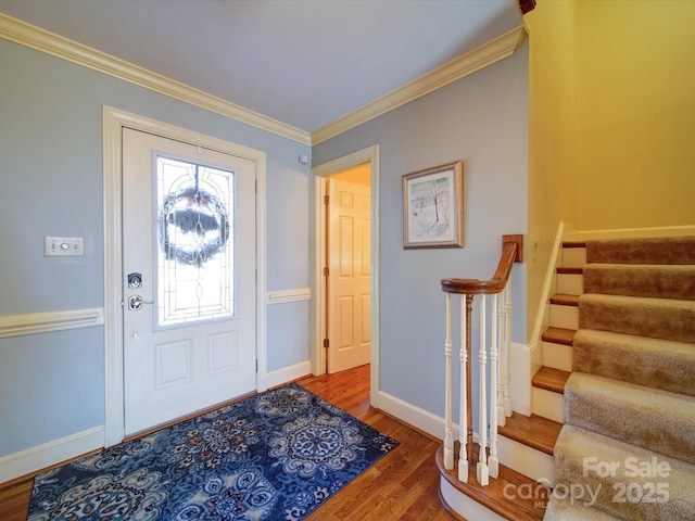 foyer with a healthy amount of sunlight, hardwood / wood-style flooring, and ornamental molding