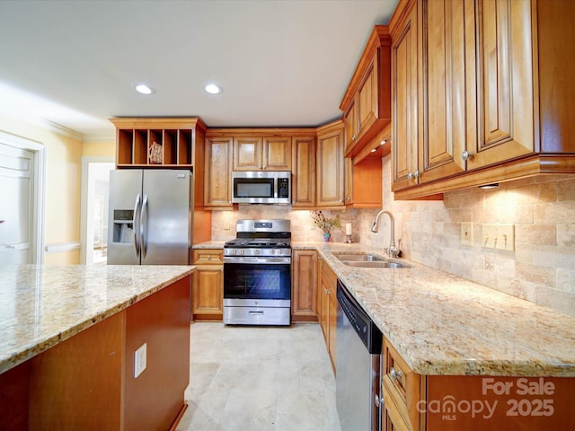 kitchen featuring tasteful backsplash, light stone counters, sink, and stainless steel appliances