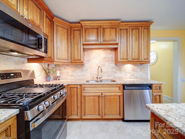 kitchen with light stone counters, sink, stainless steel appliances, and tasteful backsplash