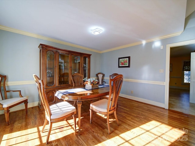 dining area with ornamental molding and light wood-type flooring