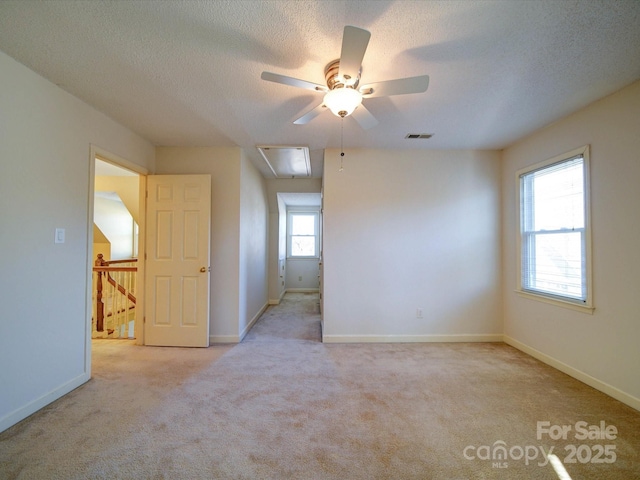 carpeted empty room featuring ceiling fan and a textured ceiling