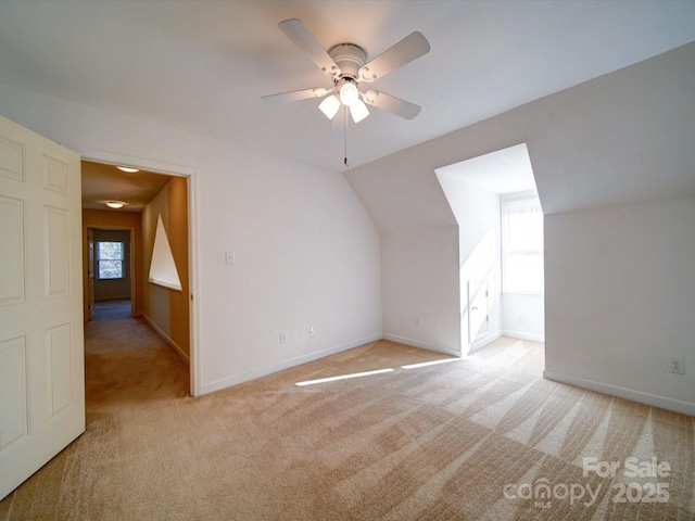 additional living space featuring light colored carpet, vaulted ceiling, and ceiling fan